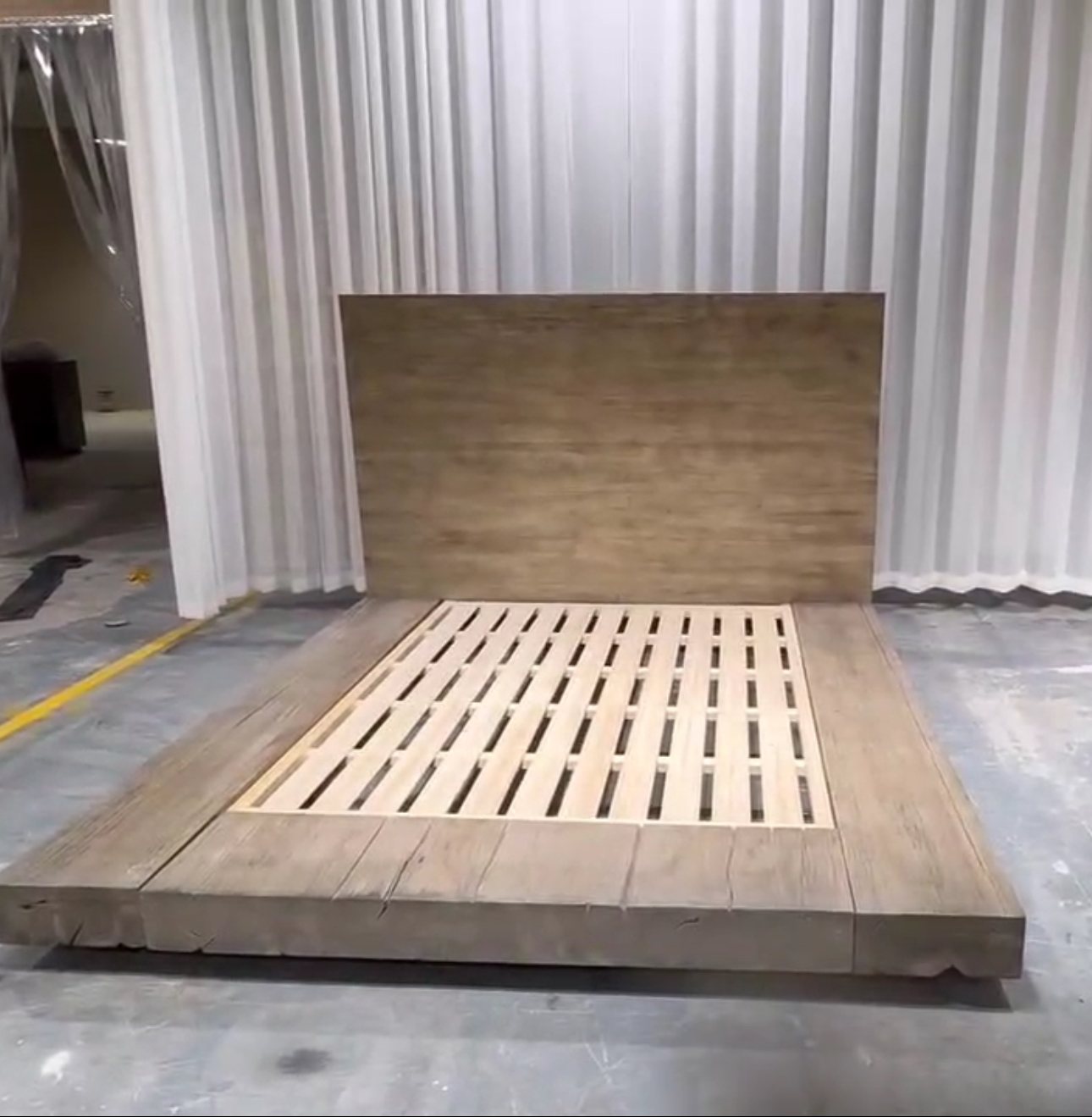 Reclaimed wood platform bed with a solid panel headboard